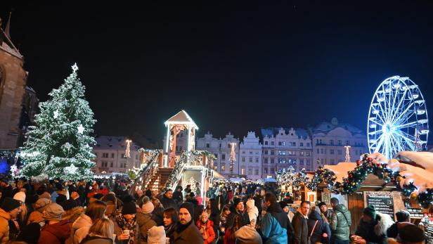 Menschen am Weihnachtsmarkt in Pilsen vor Bürgerhaus Fassaden, Weihnachtsbaum und Riesenrad